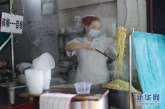 4月22日，武漢市糧道街的家陽“趙師傅”天天紅油熱干面店廚師在制作熱干面。新華社記者 沈伯韓 攝