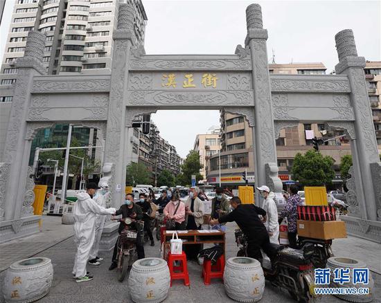  4月16日，進(jìn)出武漢漢正街步行街的人員在掃描健康碼。新華社記者 王毓國 攝